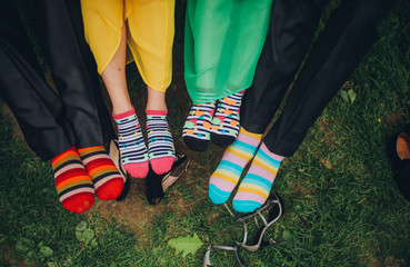 Feet in four people in colored socks outdoor