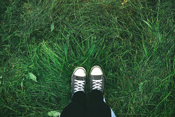 Young man standing in freshly mown grass lawn