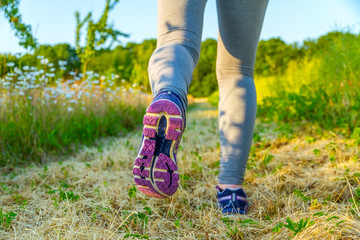 Woman running at sunset in a field