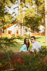 Naklejka premium Young couple in love walking in the autumn park holding hands looking in the sunset