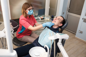 A dentist examines his patient's teeth. Action in the dental clinic