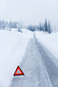 A warning triangle on a country road in the winter, Sweden.