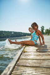 Zwei Kinder plantschen im Wasser im Sommer