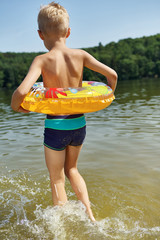 Junge von hinten plantscht im Wasser