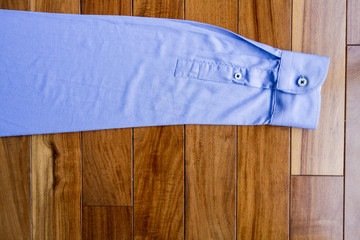 Sleeve blue shirt on wooden floor 
