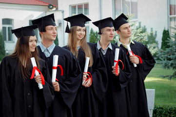 Group of graduates with diplomas in their hands