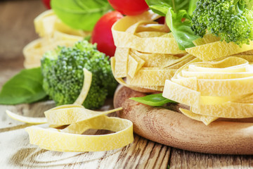 Raw pasta fettuccine, fresh broccoli, green basil leaves, red ch