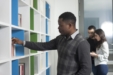 Students searching for books in the library