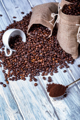 Coffee seeds in spoon with some jute bags and cup.