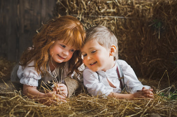 Red-haired girl and boy playing with rabbit in the hay 6119.