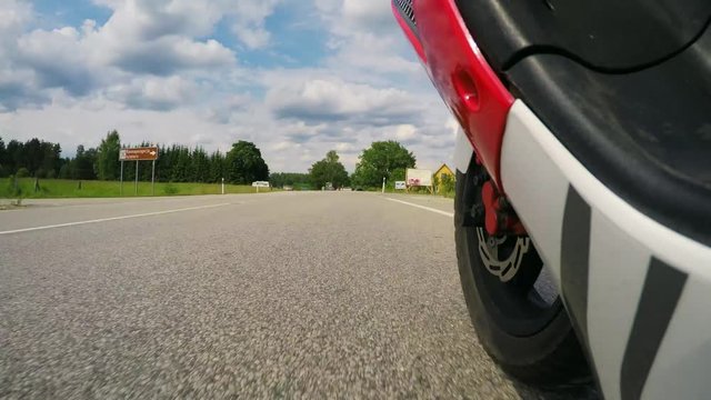 Driving scooter - Operator low Point of View. Man Riding a motorcycle in the for