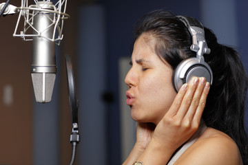 Female recording artist singing into the microphone