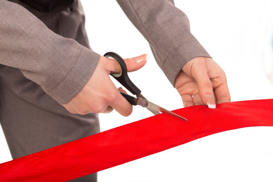 woman hand Cutting red ribbon isolated on white