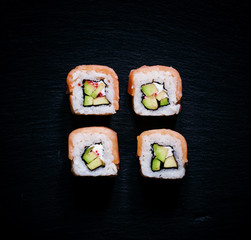 Rolls with salmon, cream cheese and avocado, dark food backgroun