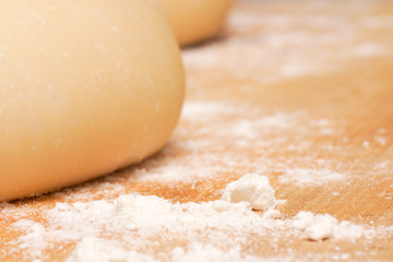 Freshly made pizza dough on a wooden chopping board