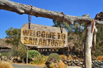 Fotobehang wood signboard with text " welcome to San Antonio" hanging on a branch © luzitanija