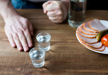 Shot glasses of vodka on a wooden table