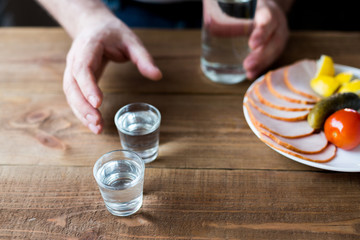Shot glasses of vodka on a wooden table