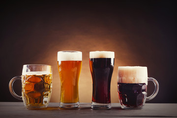 Different sorts of draft beer in glasses on wooden table. Retro stylization