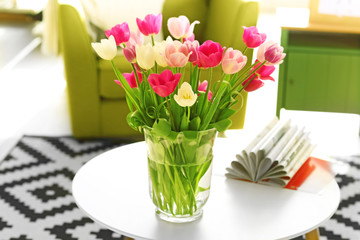 Beautiful fresh tulips on round table