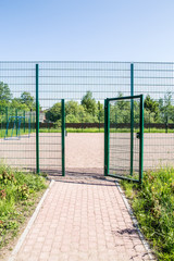 entrance to the playground of fence and the wicket of the welded wire mesh green color with a metal...