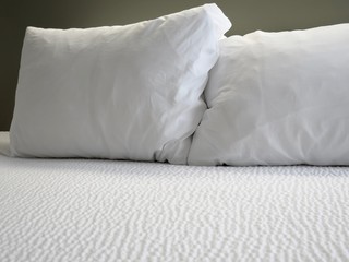 Fototapeta na wymiar Detail of bed with set of white morning bedding 
