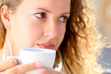 young woman drinking a coffee from cup   