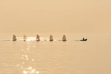 Abwaschbare Fototapete Wasser Motorsport Gruppe von Optimisten-Segeln in Portbu-Schlauchboot geschleppt