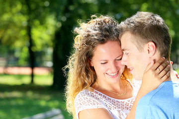 Close-up side view of a loving couple embracing in the park