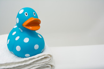 Cute Rubber Duck on a White Towel in Bathroom Close Up