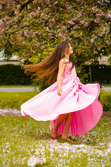 Obraz na płótnie Canvas Little girl in pink dress with blossom