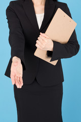portrait of asian businesswoman shaking hand isolated on blue background
