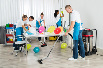 Janitors Cleaning The Office After Party