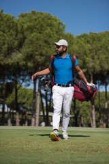 Obraz premium golf player walking and carrying bag