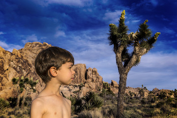 Boy in profile with a Yucca in Joshua Tree, mountains in the back.
