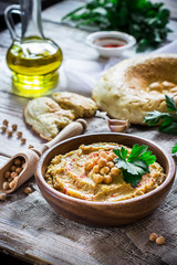Hummus in wooden bowl  on the table.