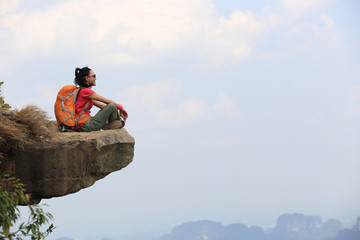 successful woman hiker  enjoy the view at mountain peak cliff