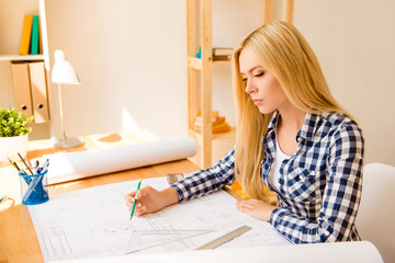 Young smart woman drawing plan of new house