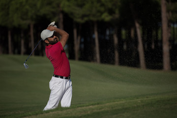 golfer hitting a sand bunker shot