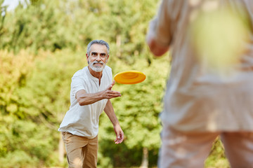 Paar Senioren beim Frisbee spielen