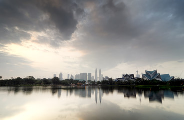 Fototapeta premium blurred image backgroud of Kuala Lumpur City with reflection on the lake and dramatic cloud