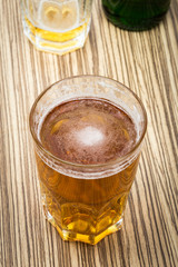 beer in the glass and covers on wooden table