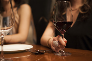 Women are holding a glass of red wine