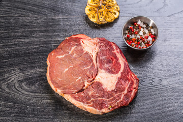 Raw beef steak on a dark wooden table