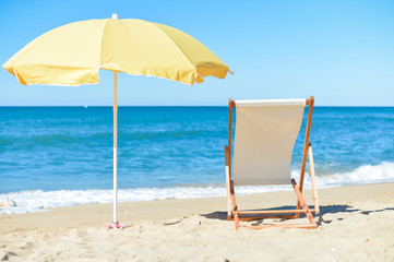 Back View Of Deckchair, Sun Lounger Under Umbrella On Sand Beach. 