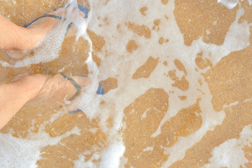 Closeup on feet, outside beach sand background. Top view, happy moments