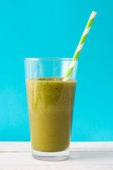 Healthy green detox with spinach on blue background