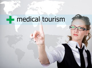 medical tourism written on a virtual screen. Internet technologies in business and tourism. woman in business suit and tie, presses a finger on a virtual screen