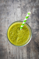 Healthy green detox with spinach, cucumber, lime and apples on a rustic wooden table
