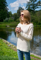 Girl in the park with a cup of coffee